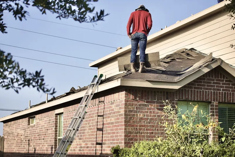 Professional roofer working on a residential roof in Peters Corner